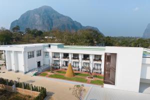 un edificio blanco con una montaña al fondo en Daoneua Riverside Resort, en Muang Fuang
