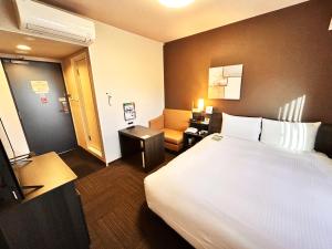 una habitación de hotel con una cama grande y una silla en Hotel Route-Inn Anan, en Anan 22 fotos más