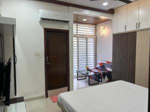 een slaapkamer met een bed en een deur naar een kamer bij Indore Home stay in Indore +3 foto's