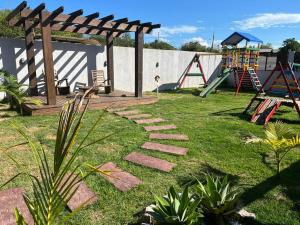 a garden with a pathway and a playground at POUSADA ROSA e POESIA in Praia do Rosa