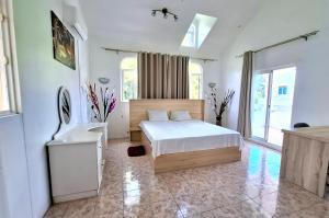 Postel nebo postele na pokoji v ubytování Villa Mauricienne à Calodyne - Piscine privée - 200m plage
