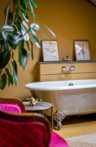 ein Badezimmer mit einer Badewanne, einem Tisch und einer Pflanze in der Unterkunft Communal Hotel Telavi in Telawi + 58 Fotos