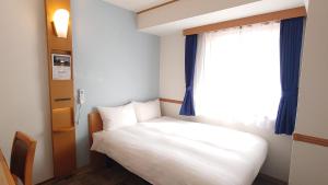 Postel nebo postele na pokoji v ubytování Toyoko Inn Niigata Ekimae