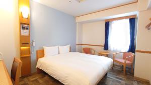 Postel nebo postele na pokoji v ubytování Toyoko Inn Niigata Ekimae