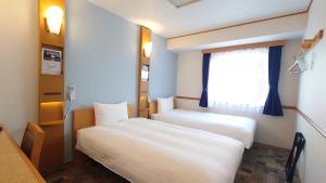 Postel nebo postele na pokoji v ubytování Toyoko Inn Niigata Ekimae