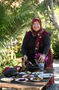 Eine Frau steht neben einem Tisch mit Essen. in der Unterkunft Agora Pansiyon in Kapıkırı