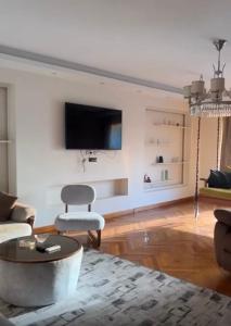 Una sala de estar con un televisor en la pared. en شقه بكورنيش النيل, en El Cairo