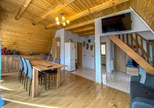 a kitchen and dining room with a table and chairs at Sunrise View Chalet in Trăisteni