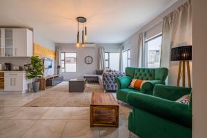 Una sala de estar con un sofá verde y una mesa. en Beach Terrace at Starfish 42, en Swakopmund