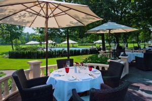 una mesa con copas de vino y sombrillas en un restaurante en Parkhotel De Wiemsel en Ootmarsum