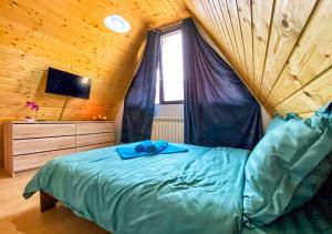 a bedroom with a bed in a wooden room at Sunrise View Chalet in Trăisteni