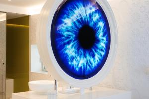 Un gran ojo azul en la pared de un baño en The Donna Portals, en Portals Nous
