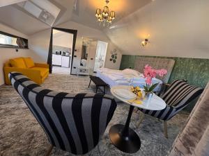 a bedroom with a bed and a table and chairs at Premont Luxury Ghimbav in Ghimbav