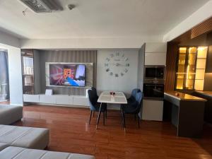 a living room with a table and a clock on the wall at Oni's guest house in Ulaanbaatar