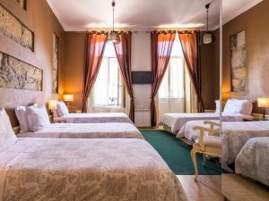a hotel room with two beds and a television at Pedra Iberica in Porto