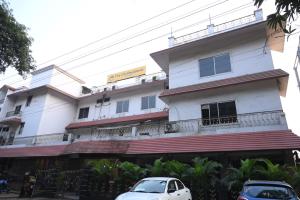 Un edificio blanco con coches aparcados delante. en The Citi Residenci Hotel, Bidhannagar, en Durgāpur