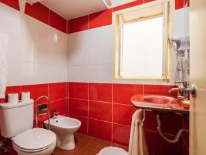 a red and white bathroom with a toilet and a sink at Pedra Iberica in Porto