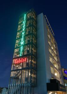 東京にあるTabist 東京シティビューホテルのネオンの看板が貼られた高層ビル