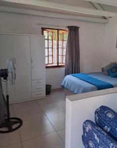a bedroom with two beds and a window at Beach Walk Cottage in Plettenberg Bay