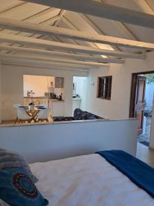 a bedroom with a bed and a living room at Beach Walk Cottage in Plettenberg Bay