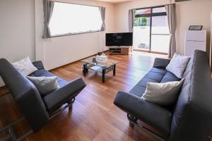 a living room with two couches and a table at Bhome Hikone Jizo in Hikone