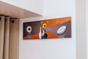 a painting of vases and flowers on a wall at Witty Weekend retreat Quirk Cozy in Manila