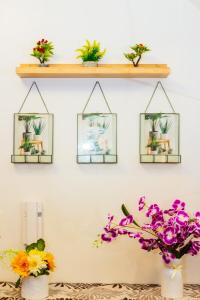 a shelf filled with plants and flowers on a wall at Witty Weekend retreat Quirk Cozy in Manila