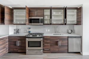 a kitchen with stainless steel appliances and wooden cabinets at Soma 1br w pool gym nr transport SFO-1475 in San Francisco