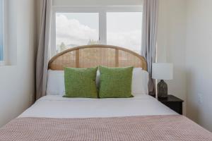a bedroom with a bed with green pillows and a window at Blueground Berkeley AC wd nr UC Theatre SFO-1814 in San Francisco