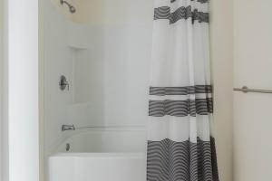 a bathroom with a black and white shower curtain at Blueground Berkeley AC wd nr UC Theatre SFO-1814 in San Francisco +9 photos