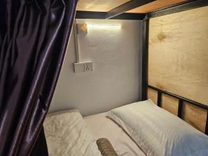 a small bedroom with a bunk bed with a canopy at AeCOTEL Mingle Hostel in Sandakan +28 photos
