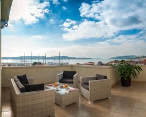 einen Balkon mit Stühlen und einem Tisch mit Blick auf das Wasser in der Unterkunft Hotel Rotondo in Trogir