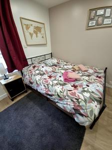 a bedroom with a bed with a floral bedspread at Abelia-Confort et Sérénité au coeur de la ville in Palaiseau