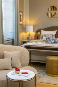 a bedroom with a bed and a couch and a table at Hotel Taschenbergpalais Kempinski in Dresden