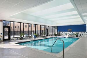 a swimming pool in a hotel lobby with a large window at Doubletree By Hilton Battle Creek in Battle Creek