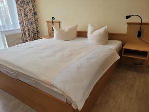 a large bed with white sheets and pillows on it at Zinnowitz, Dünenstr 36 WE 15 in Zinnowitz +9 photos