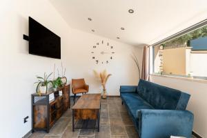 Una sala de estar con un sofá azul y una mesa. en Mas de l'Acqueduc, en Le Barroux