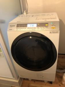 a white washing machine sitting in a room at hostel+cafe たね in Hōgano