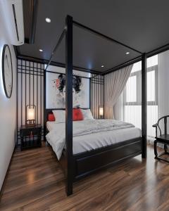 a bedroom with a black canopy bed with white sheets at Dal Vostro Vinhomes Ocean Park 2 in Ðình Loan