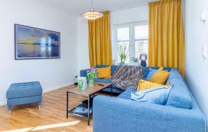 a living room with a blue couch and a table at Villa Sjöbris - Lake Vänern in Ängenäs