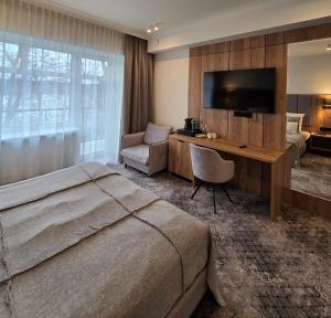 a bedroom with a bed and a desk with a television at Ośrodek Wypoczynkowy Łańsk in Stawiguda +179 photos