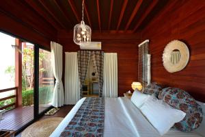a bedroom with a bed and a chandelier at The Blue Sky Resort @ Koh Payam in Ko Phayam