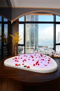 a cake with red roses on top of a table at The Granite Luxury Hotel Penang in George Town