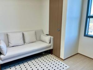 a white couch sitting in a room with a window at Donghae beach hanseom in Donghae