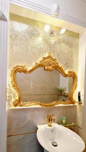 a bathroom with a gold mirror above a sink at Biệt Thự cao cấp Lâu Đài Nhỏ Đà Lạt - Little Castle Da Lat Villa in Da Thien +83 photos