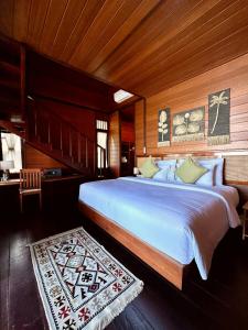Schlafzimmer mit einem großen weißen Bett und Holzwänden in der Unterkunft Yenatar Resort in Friwin