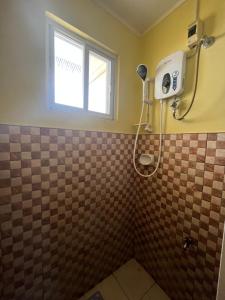 a bathroom with a shower with a window at Cebrian Apartment Rental Unit 2 in Buenavista