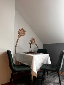 a table with green chairs and a lamp on it at Fremdenzimmer Pehn in Ottenschlag +13 photos