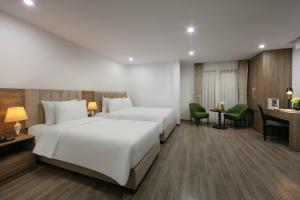 a hotel room with two beds and a desk at Emissary Corner Hanoi Hotel & Spa in Hanoi +45 photos