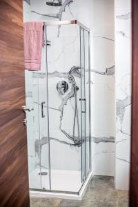 a bathroom with a shower with marble walls at Qawra Two bedroom new apartment in St Paul's Bay +19 photos